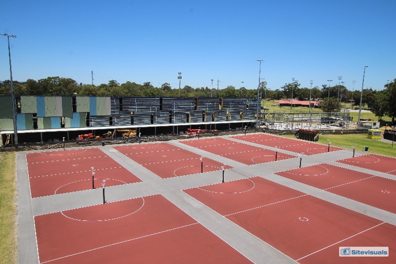 Steel structure behind outdoor netball courts with panelling work commencing